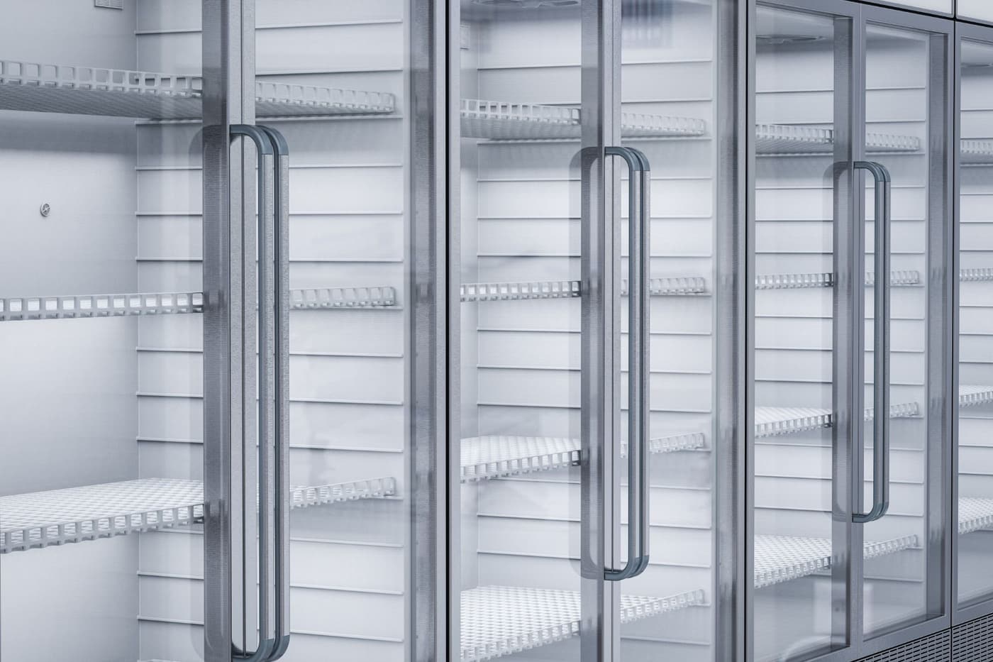 A row of empty refrigerators with glass doors in a store.