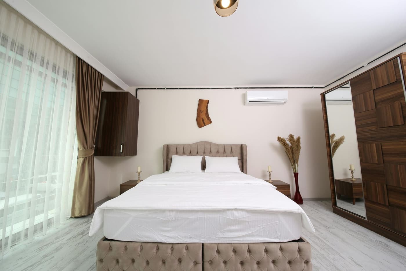 Bright bedroom with a wall-mounted ductless mini split unit near the ceiling